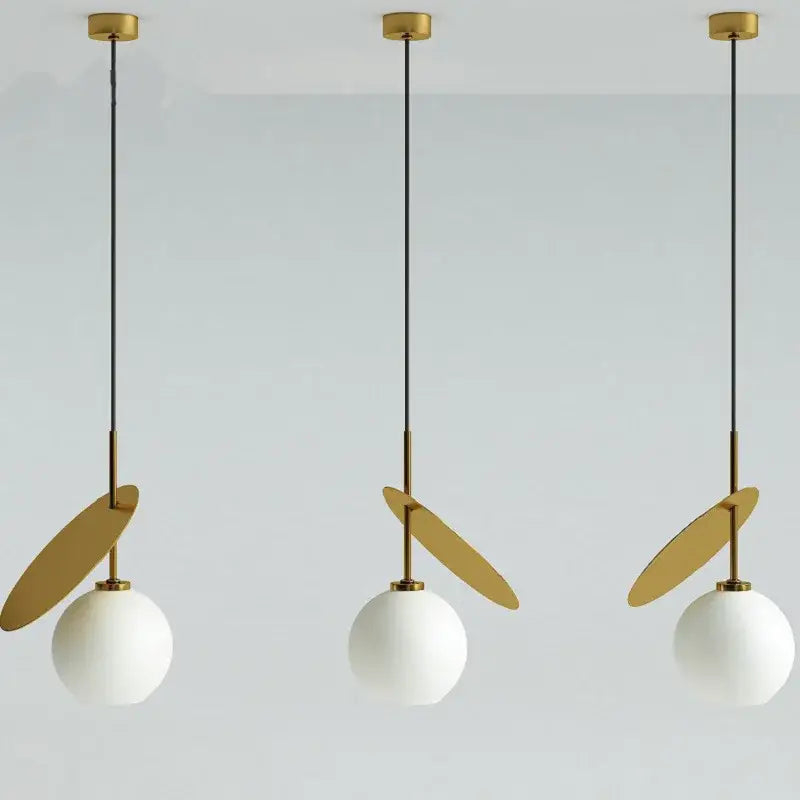 Three modern pendant lights with gold-toned metal fixtures and white cherry glass pendant shades by DecorBites cherry glass