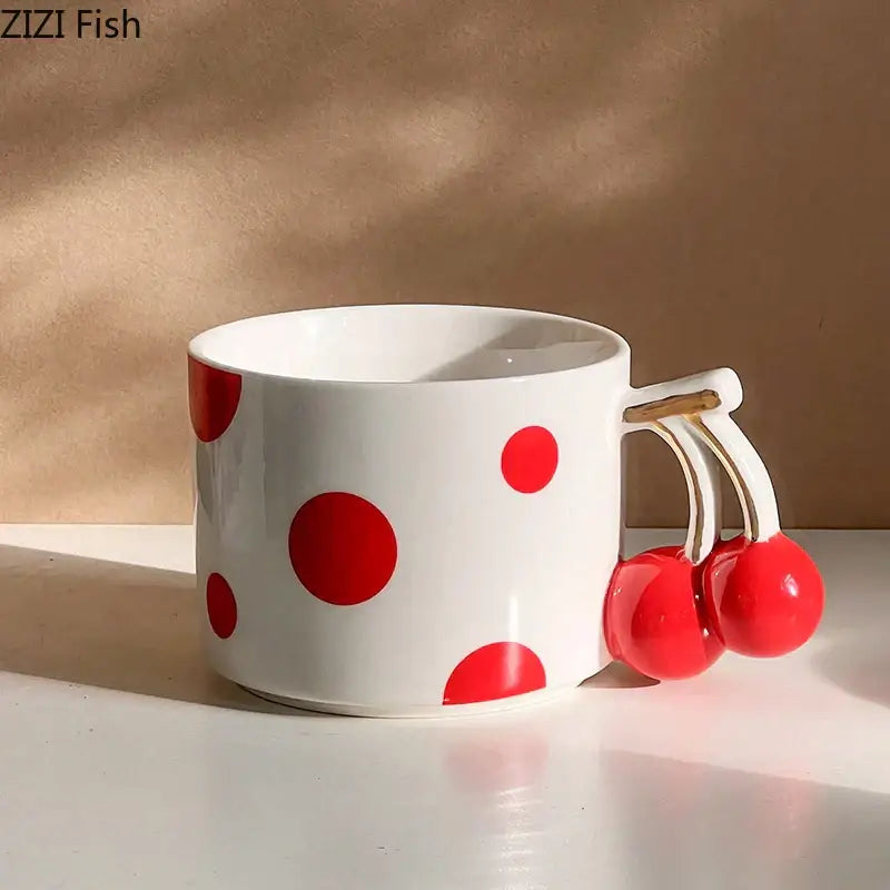 White ceramic coffee mug with bold red polka dots and a playful decorbites cherry handle gold plated design