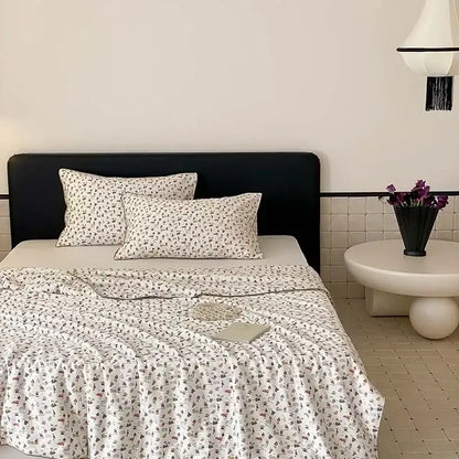 White bedding set with delicate gray and muted pink floral pattern featuring decorbites cherry lyocell fiber cooling blanket