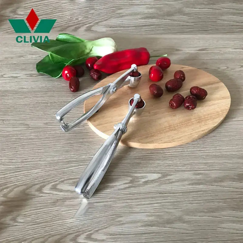 Two silver aluminum alloy decorbites cherry pitters with rounded ends designed for efficient seed extraction in kitchen use