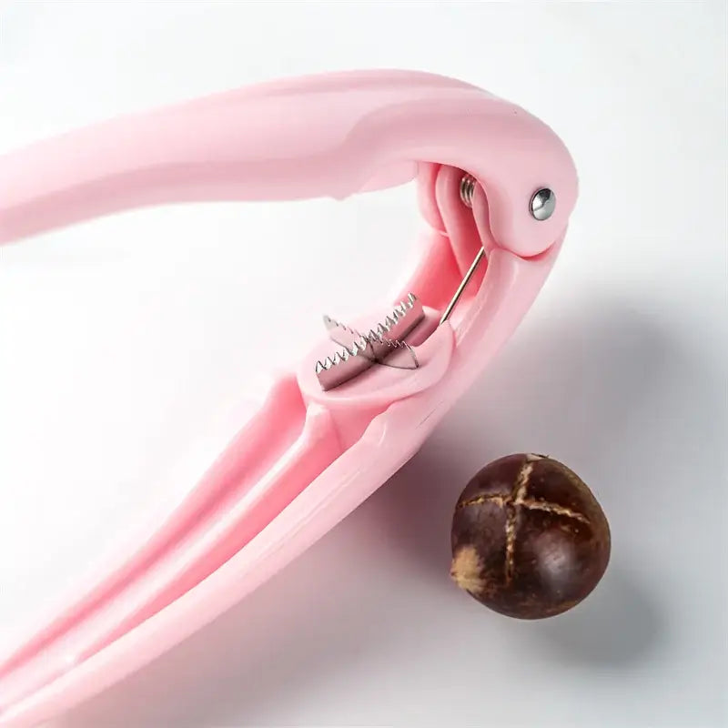 Pink plastic decorbites chestnut cracker with metallic spring mechanism for cracking nuts like pecans and walnuts