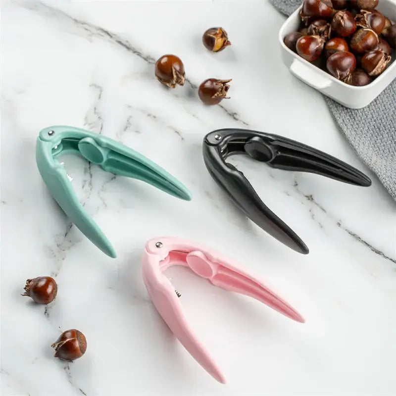 Three colorful decorbites chestnut cracker tools in mint green black and pink for easy nut shelling in kitchen