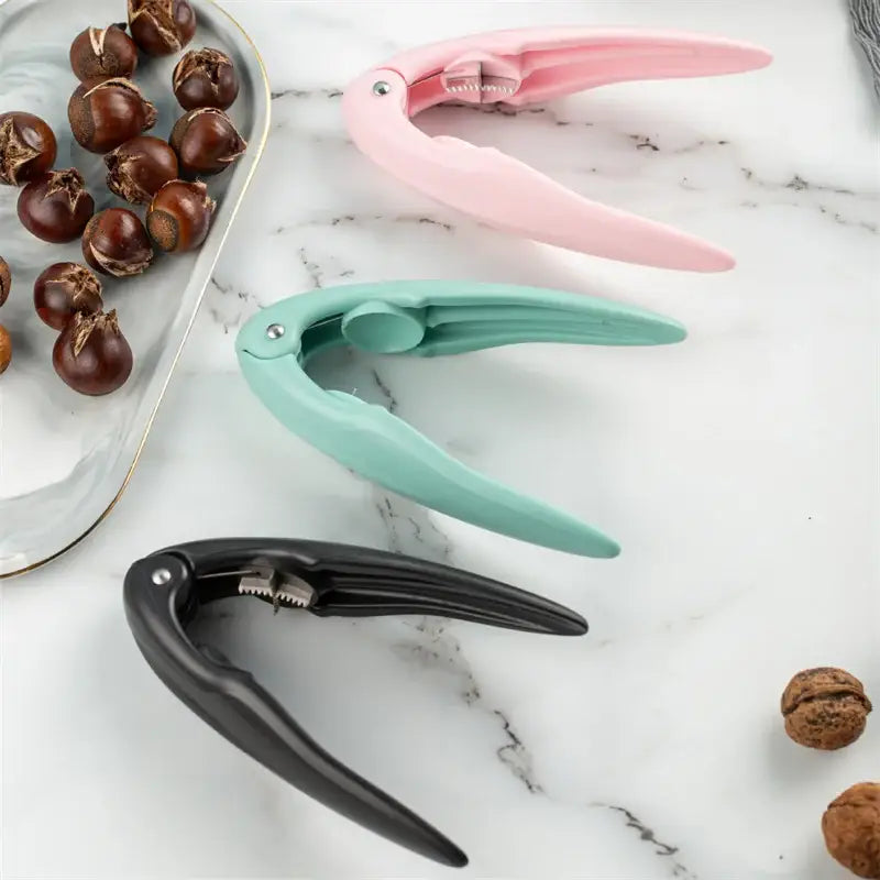Pink plastic decorbites chestnut cracker with metallic hinge and serrated edge for cracking nuts and shells