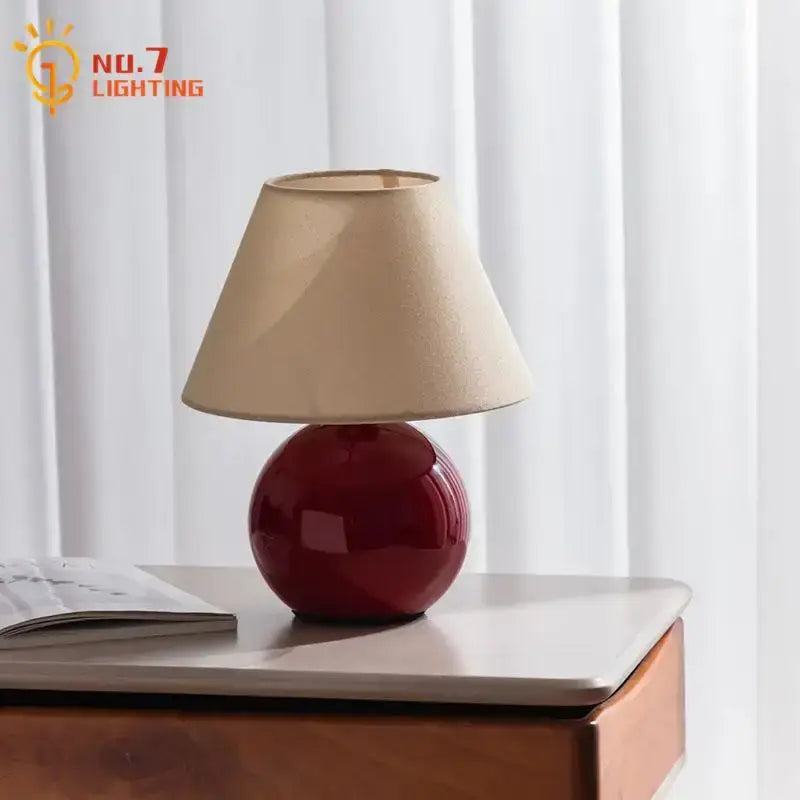 A glossy red ceramic table lamp with beige fabric shade from decorbites chestnut glass table lamp collection for bedroom use