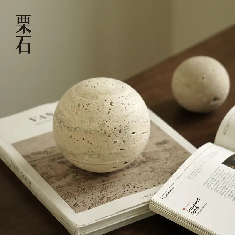 Cream-colored textured stone sphere with speckled surface decorative wabi sabi wind rock figurine by DecorBites