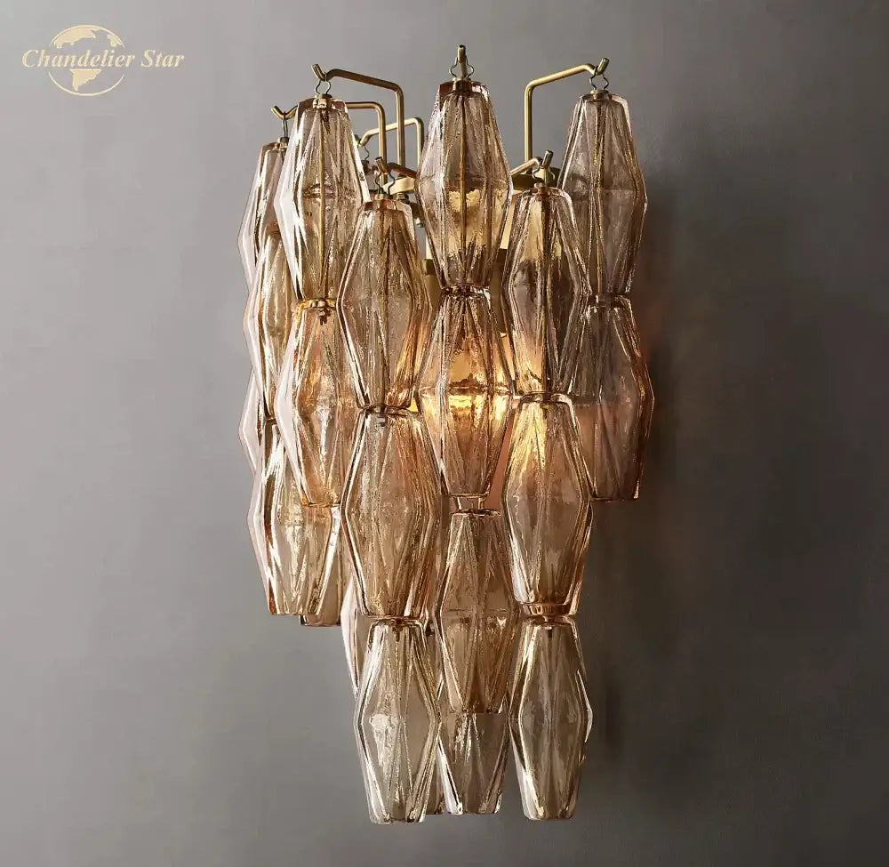 A cascading decorbites chiara glass led wall sconce with faceted amber glass shades and a brass frame