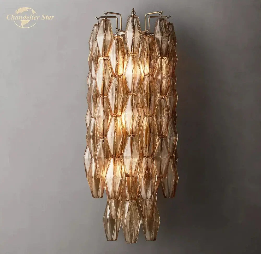 A warm-toned, geometrically faceted decorbites chiara glass led wall sconce with a cascading glass design