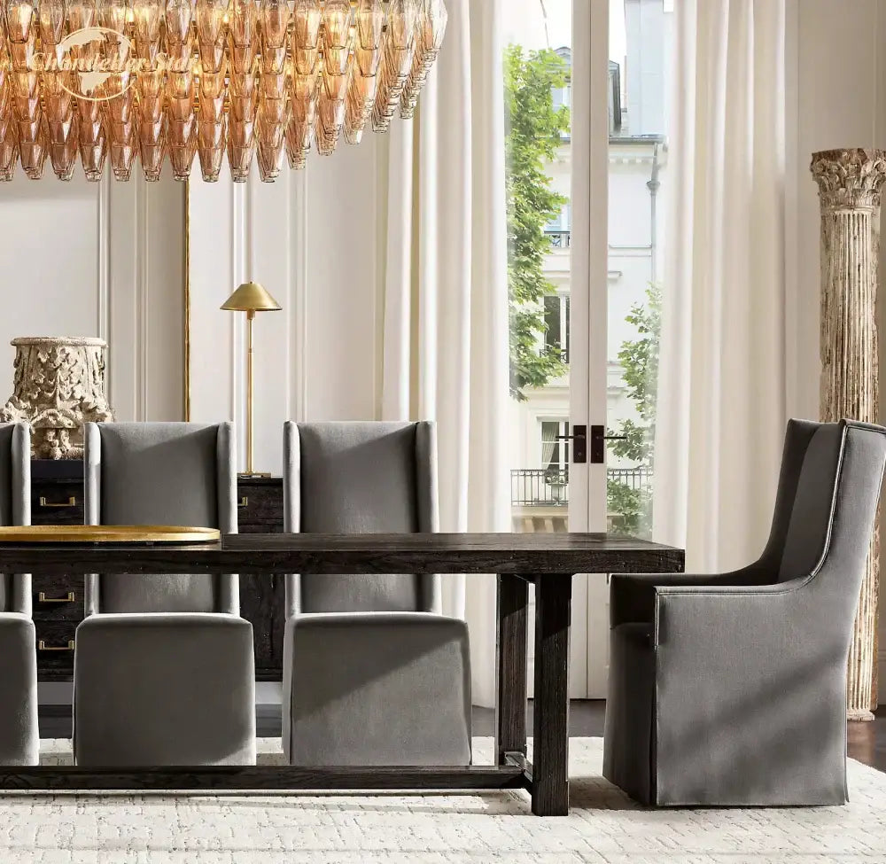 Dark wood dining table with minimalist design and polished gold centerpiece beneath decorbites chiara smoke glass tiered chandelier