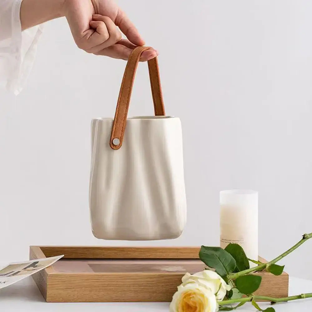 Cream-colored ceramic vase with tan leather handles by DecorBites™ chic ceramic vase for home decoration