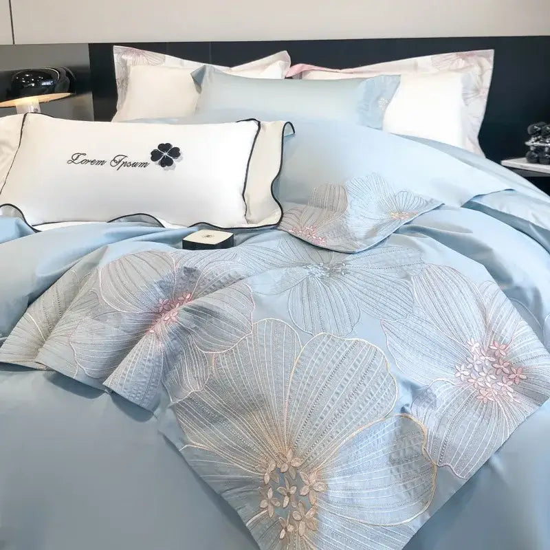 Light blue satin bedding set with delicate silver and pink floral embroidery and chic embroidered cotton pillow by DecorBites™