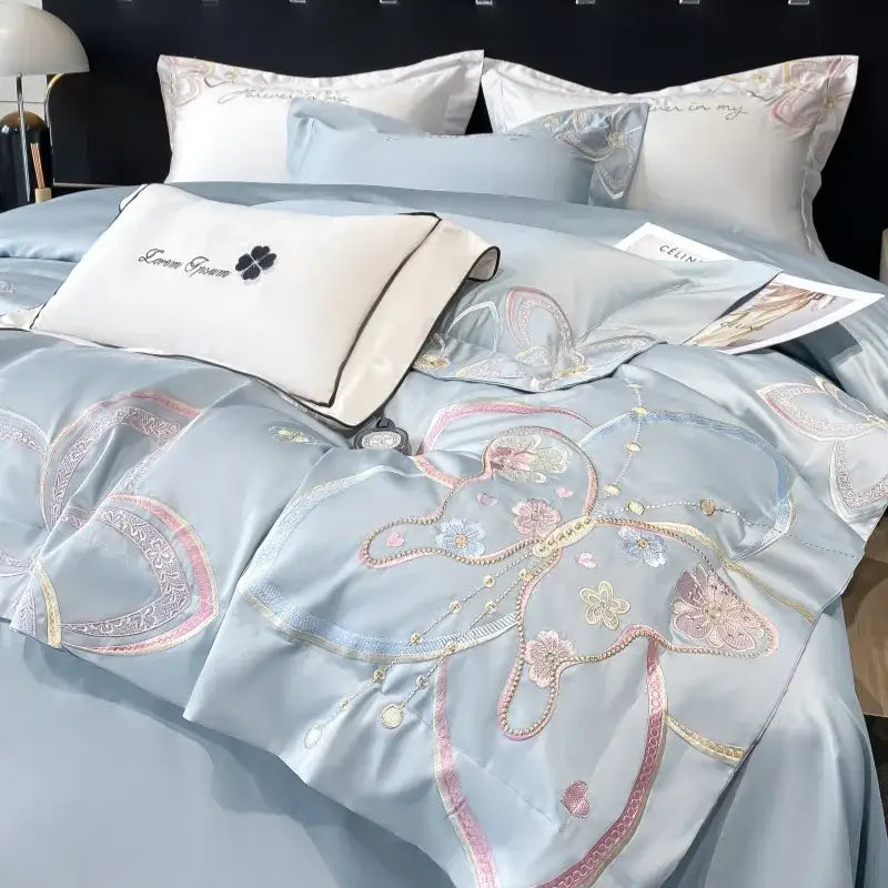 Light blue satin duvet cover with intricate pink gold and silver butterfly embroidery from decorbites chic embroidered cotton bedding set