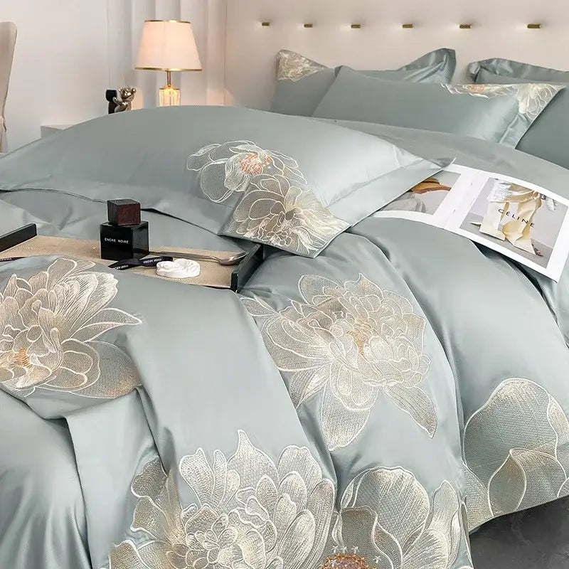 Light blue satin bedding set with intricate gold and white floral embroidery from DecorBites chic embroidered cotton collection