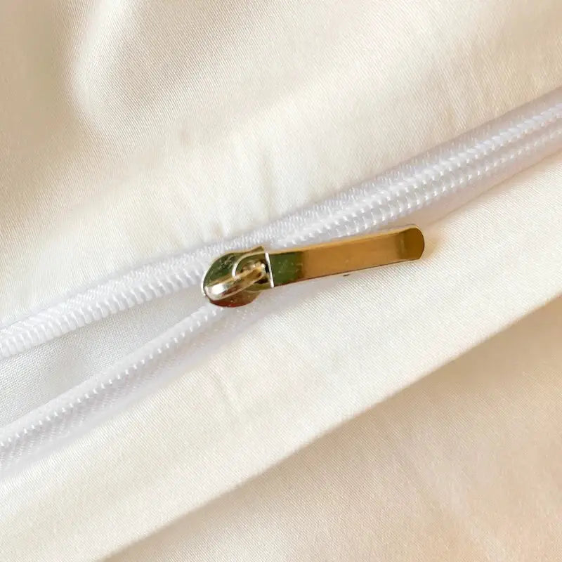Gold-toned zipper pull on white cotton fabric seam of decorbites chic flowers embroidery bedding set 400tc