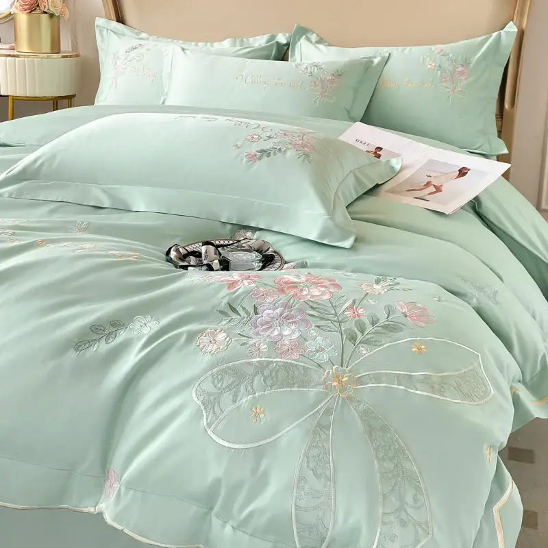 Mint green satin bedding set with intricate floral embroidery and decorative bow from decorbites chic flowers embroidery collection