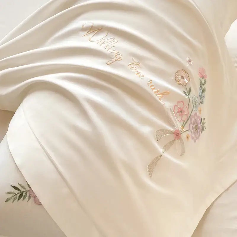 Cream-colored satin pillowcase with soft pink lavender and gold floral embroidery and matching ribbon bow from decorbites chic flowers bedding set 100 cotton 400tc