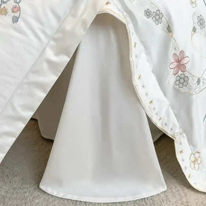 White satin bed skirt with soft pink gray and gold floral embroidery along scalloped edge in decorbites chic flowers bedding set