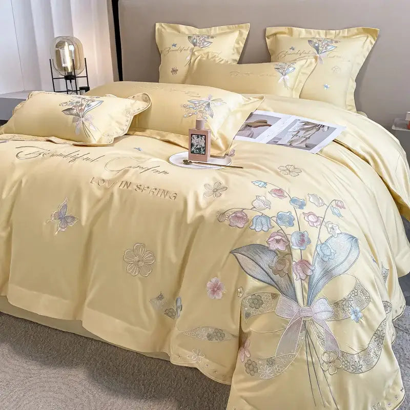 A soft yellow satin bedding set with delicate floral embroidery and lace ribbon bow by decorbites chic flowers embroidery