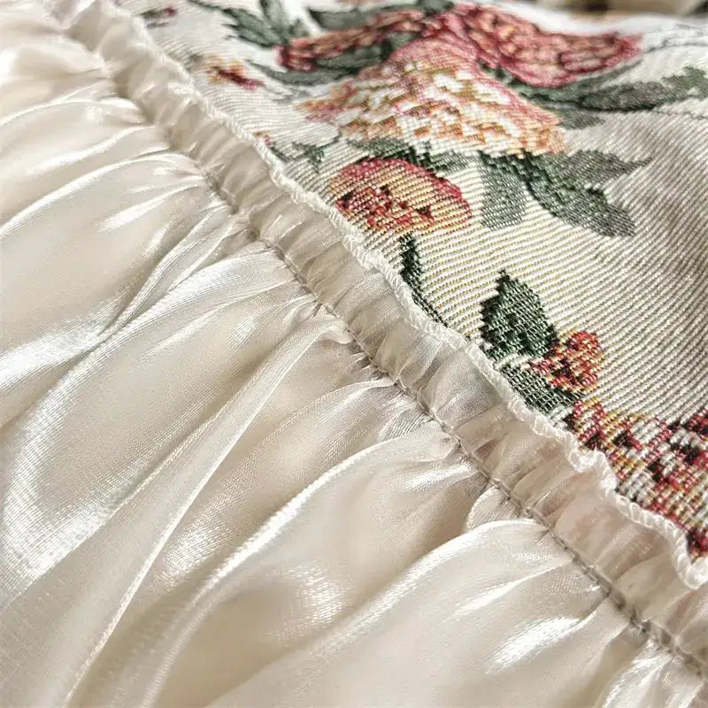 Cream-colored satin ruffle with embroidered floral pattern in pink peach and green on decorbites chic flowers jacquard bedding set