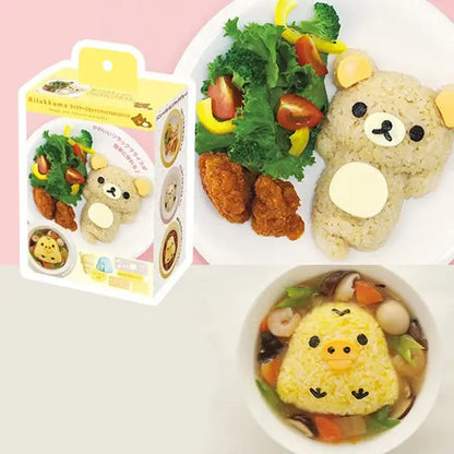 A cute yellow rilakkuma-shaped rice ball with black eyes and white belly made using the decorbites chicken bear mold set