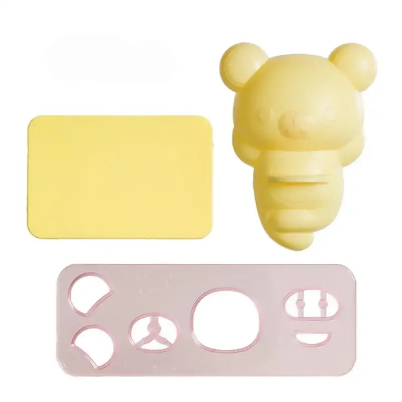 Yellow decorbites chicken bear rice ball mold set with bear-shaped cookie cutter, yellow silicone mat, and pink stencil