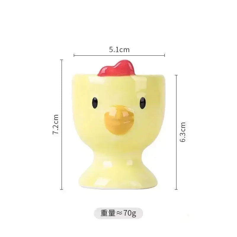 Yellow ceramic egg cup holder by DecorBites shaped like a chick with black eyes yellow beak and red comb for kids breakfast