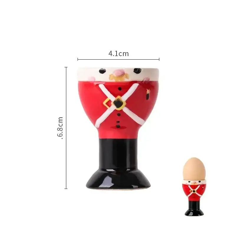 Red and black ceramic egg cup holder designed as a british soldier with white cross details and gold accents for kids breakfast