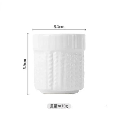 White ceramic egg cup holder with textured vertical ridges and slightly flared rim for kids breakfast use