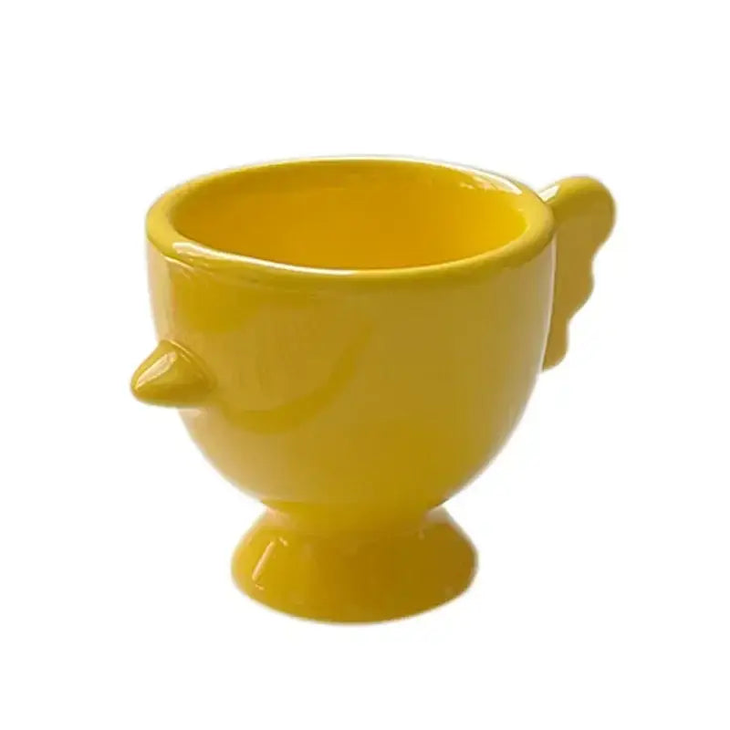 Bright yellow ceramic egg cup holder with whimsical bird features by DecorBites™ for kids breakfast tableware