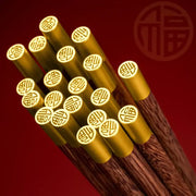Golden-tipped decorbites™ chicken-wing wood chopsticks set with intricate chinese character engravings on ends