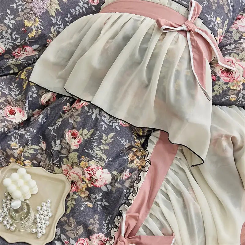A delicate cream pleated skirt with black trim and pink satin sash complementing decorbites chiffon lace ruffles bedding set