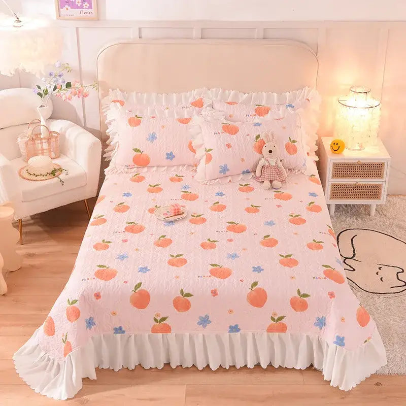 Pink peach-patterned decorbites chiffon quilted queen size cotton bedspread with white ruffled edges and blue floral accents