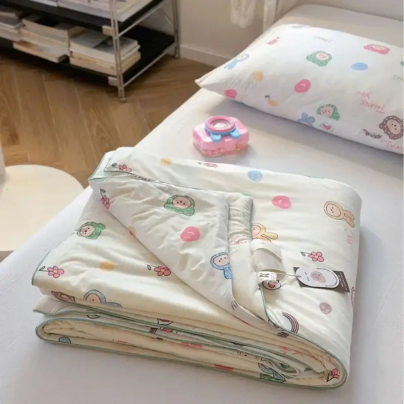 A cream-colored decorbites children cartoon summer cooling quilt with playful characters and pastel polka dots for double bed
