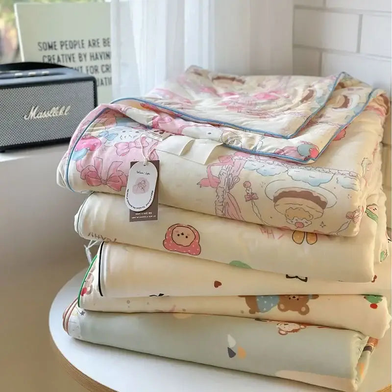 Stack of pastel-colored decorbites children cartoon quilts with soft fabric and decorative stitching for summer use