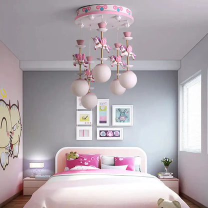 Pink and gold decorbites™ children’s carousel led chandelier with whimsical unicorn figurines and frosted globe lights