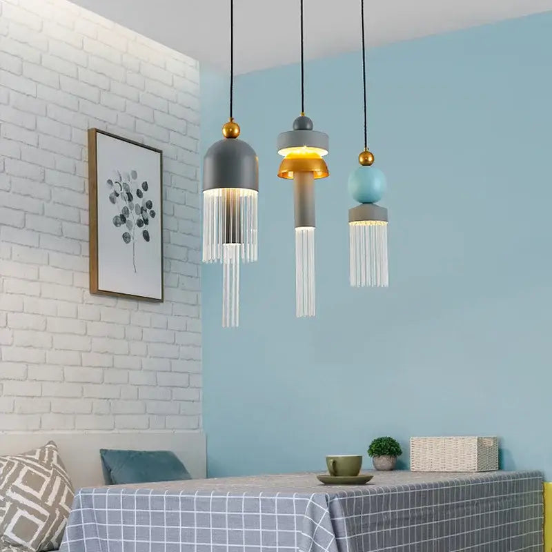 Three modern matte gray and gold-accented glass pendant lights with clear fringe for bedrooms and dining tables