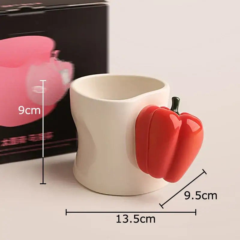 A white porcelain coffee mug with a glossy red decorbites chili handle cup shaped like a pepper on the side