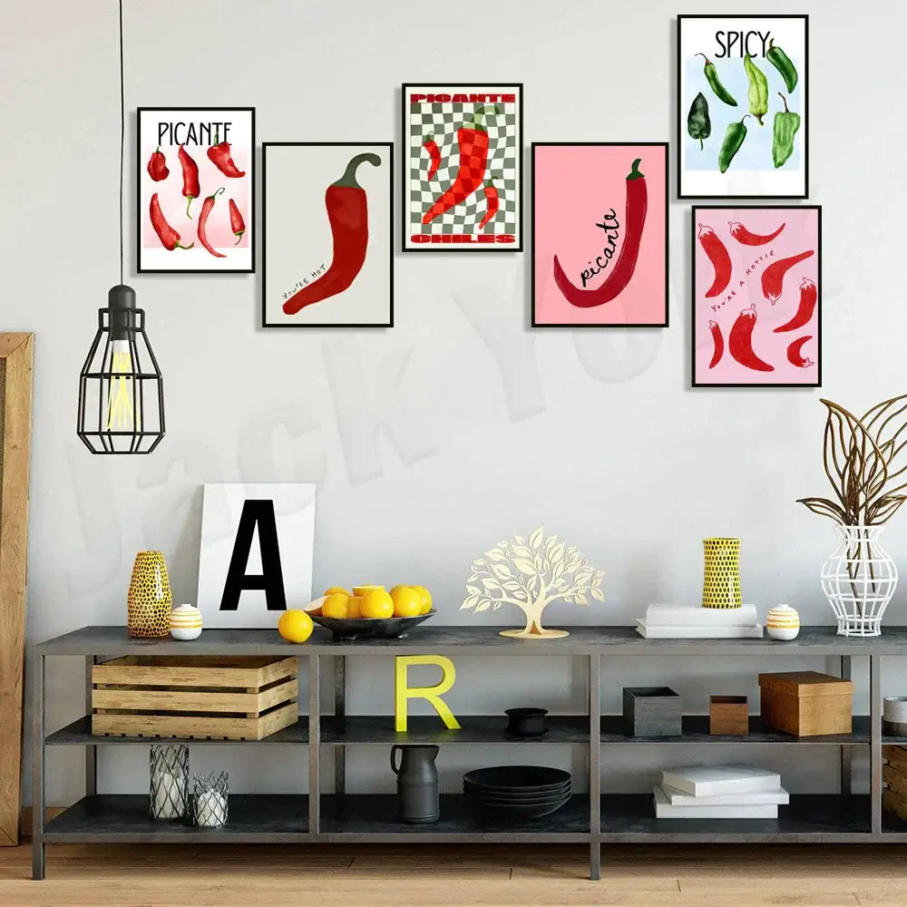 A set of five decorbites chili pepper art prints in black frames featuring red and green peppers with spicy text designs