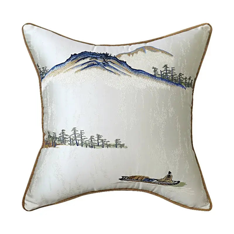 Cream-colored silk pillow cover with chinoiserie landscape embroidered featuring blue mountains and pine trees