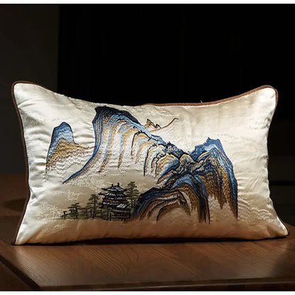 Cream-colored satin pillow cover with chinoiserie landscape embroidered in blue and gold featuring a pagoda design