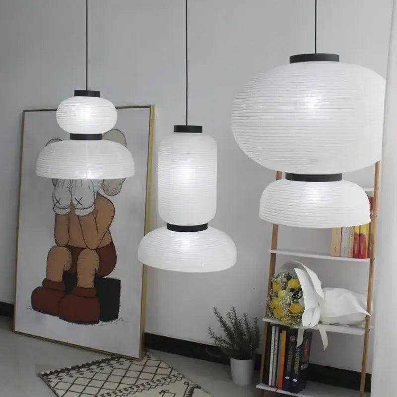 Three white ribbed paper lantern pendant lights with black metal accents from DecorBites pendant light collection