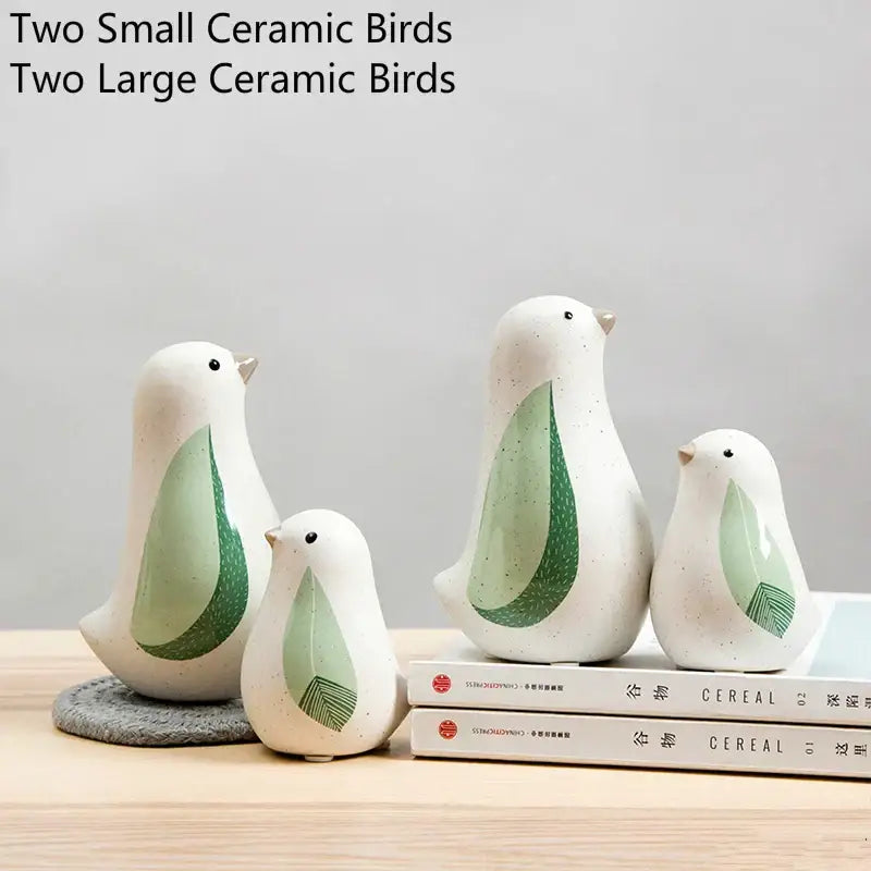 White ceramic bird figurines with green leaf-patterned wings and speckled finish for home decor by DecorBites bird figurines