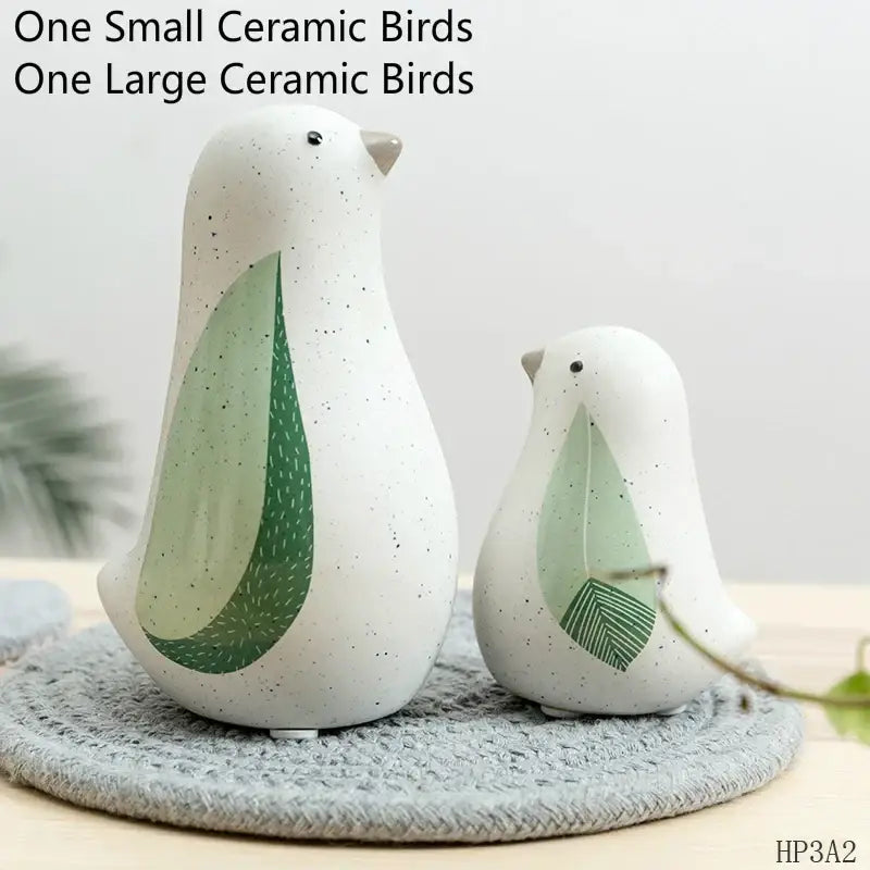 White ceramic bird figurines with speckled texture and green leaf wings for home decor by decorbites