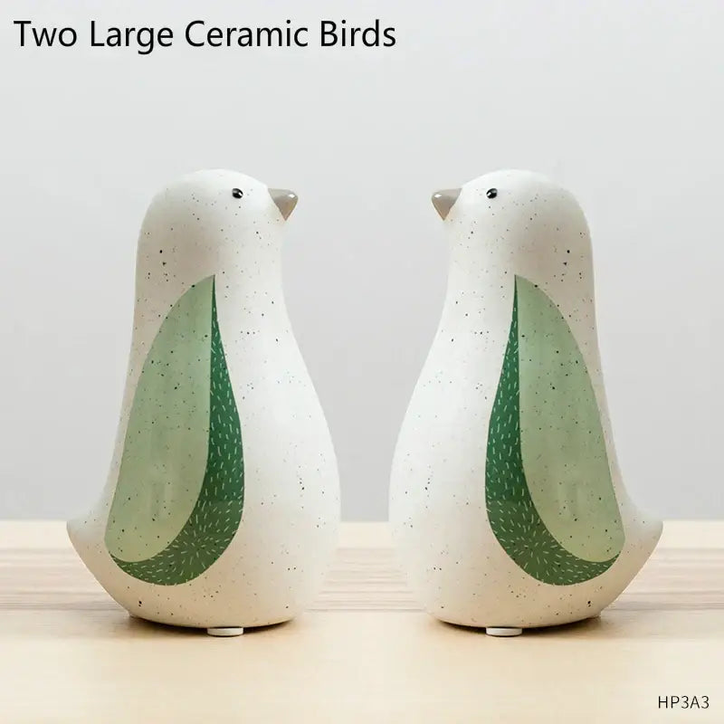 Two large ceramic bird figurines with speckled white bodies and green wing accents for home decor by DecorBites bird figurines