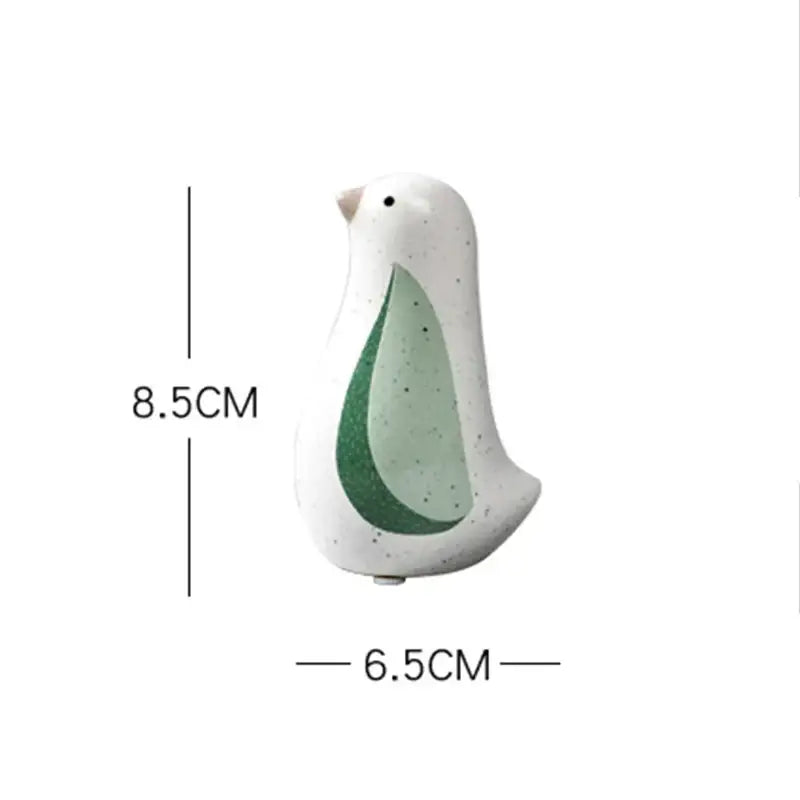 White ceramic bird figurine with speckled finish and green teardrop design from decorbites bird figurines for home decor