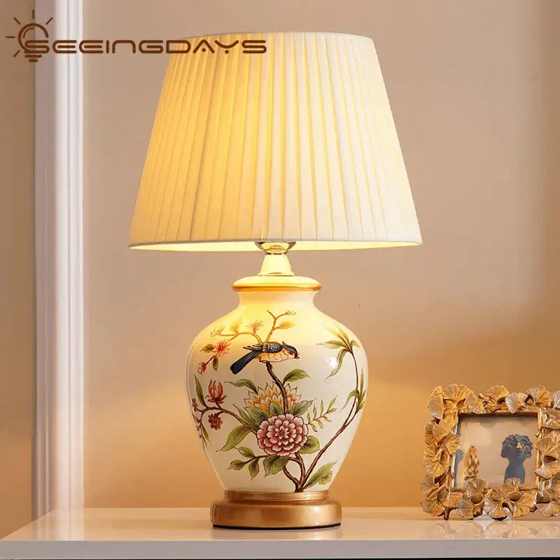Cream-colored creambites™ bird flower ceramic table lamp with hand-painted floral and bird design gold-trimmed base and rim