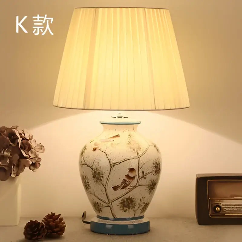 Cream-colored DecorBites™ bird flower ceramic table lamp with delicate illustrations and pleated off-white shade for bedroom