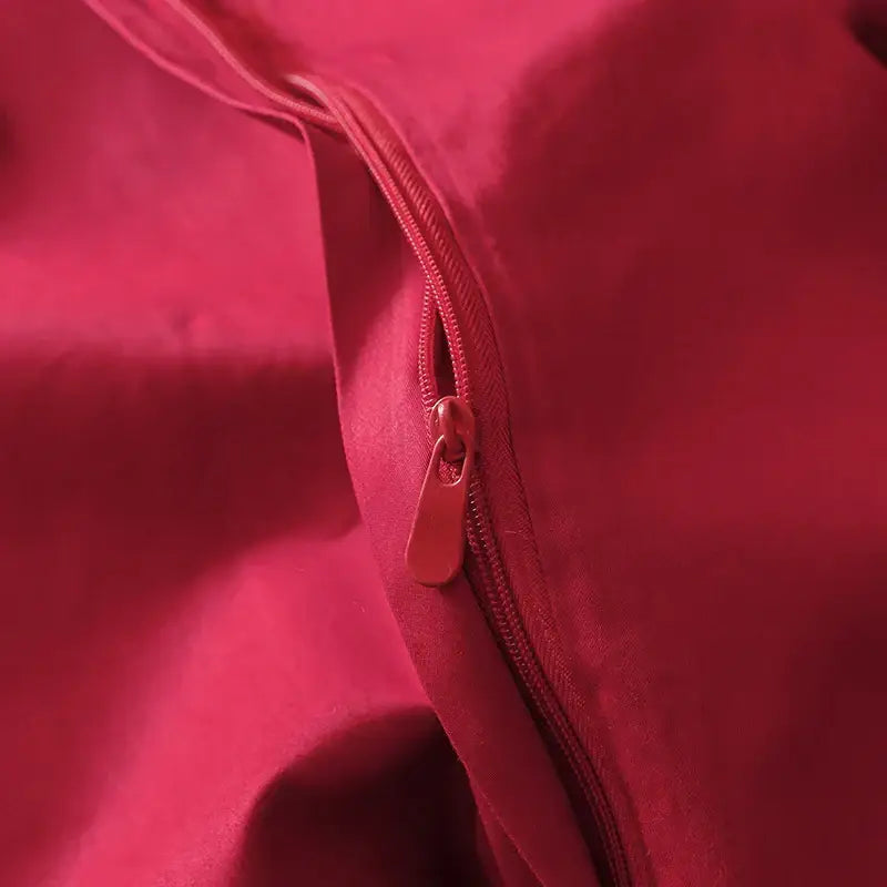 A vibrant red zipper with matching pull tab on smooth fabric of decorbites chinese butterfly flowers embroidery bedding set