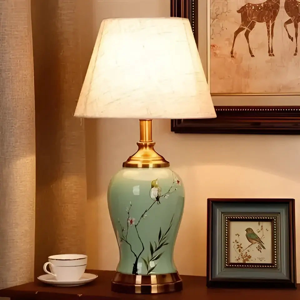 Teal and gold ceramic table lamp with hand-painted birds on branches and off-white shade for living room decor