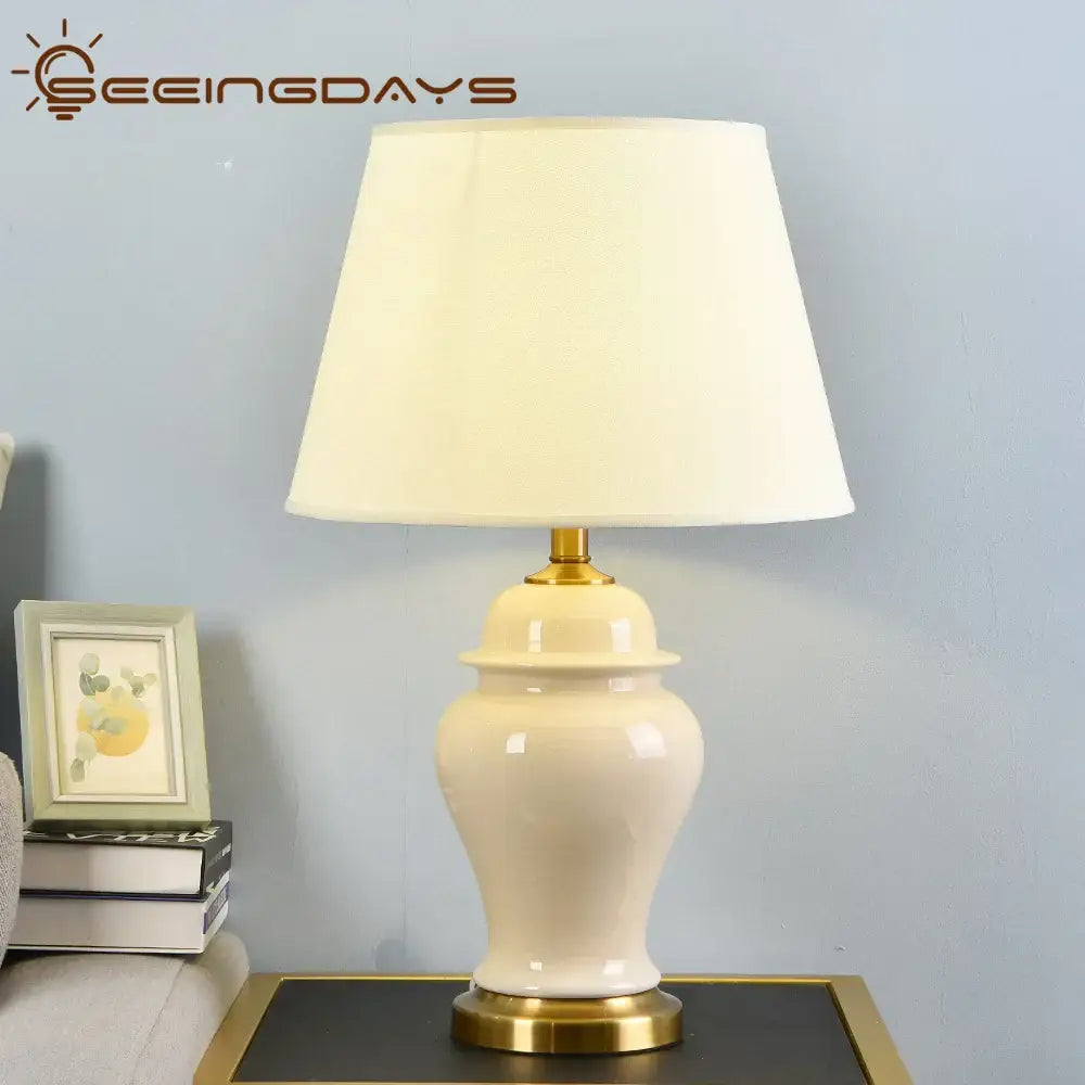 DecorBites™ cream-colored ceramic table lamp with gold metal base and off-white shade for living room and bedroom decor