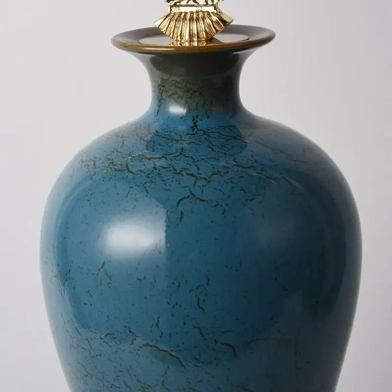 A glossy teal ceramic vase with crackled glaze and gold finial by decorbites chinese ceramic for living room decor